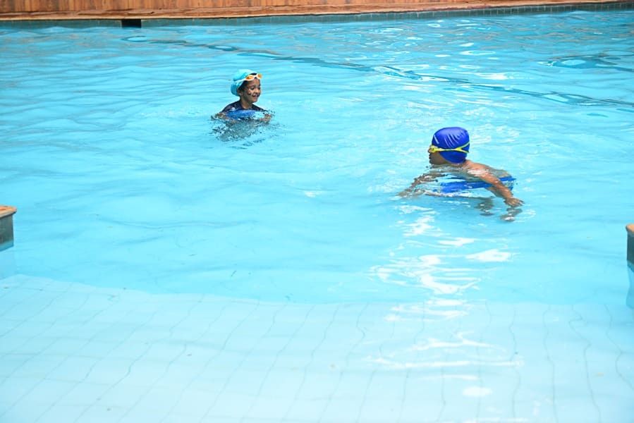 Family swimming in the pool on a birthday afternoon, shallow section in the foreground