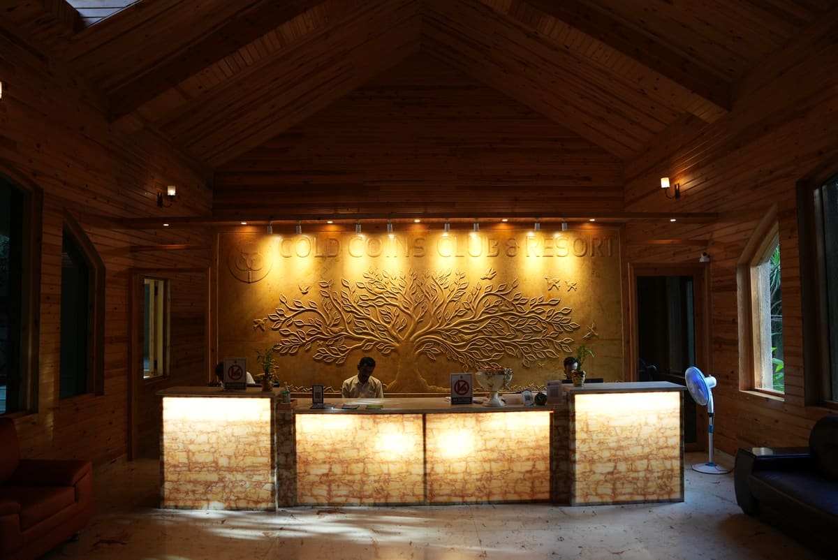 The reception at Gold Coins Club & Resort, warm wood and stone