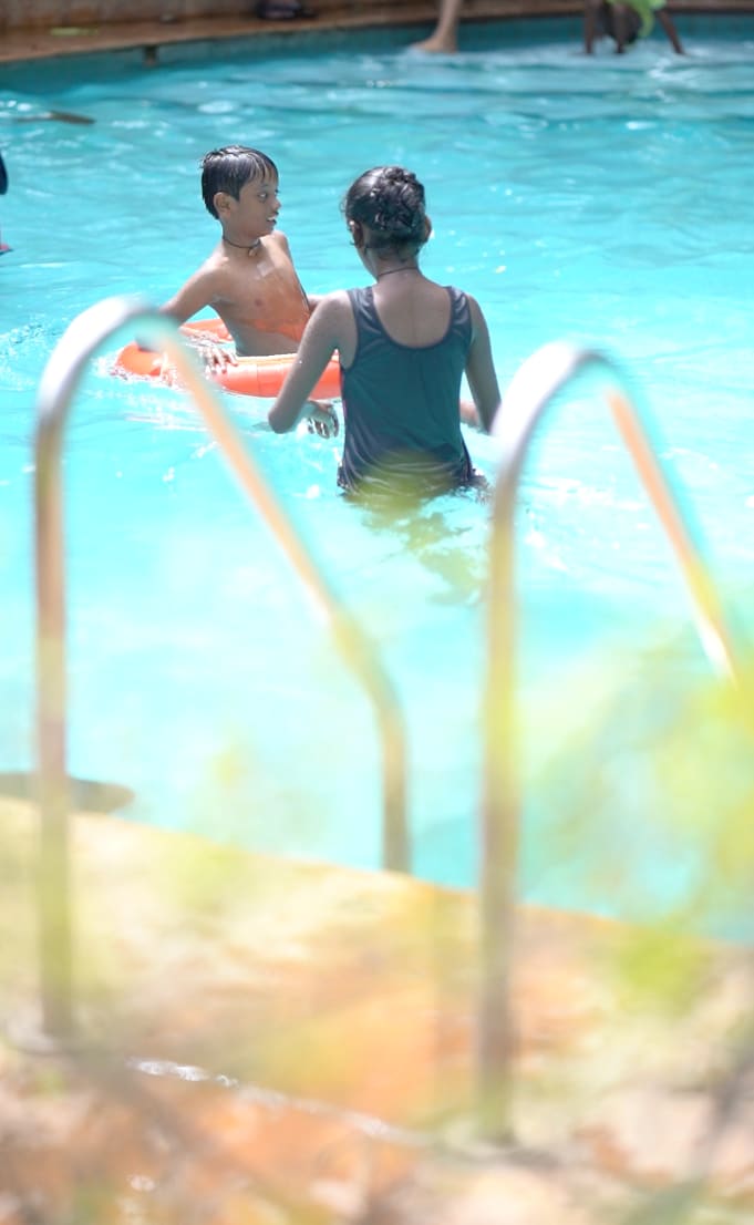 Children playing on floats in the swimming pool on a Sunday afternoon