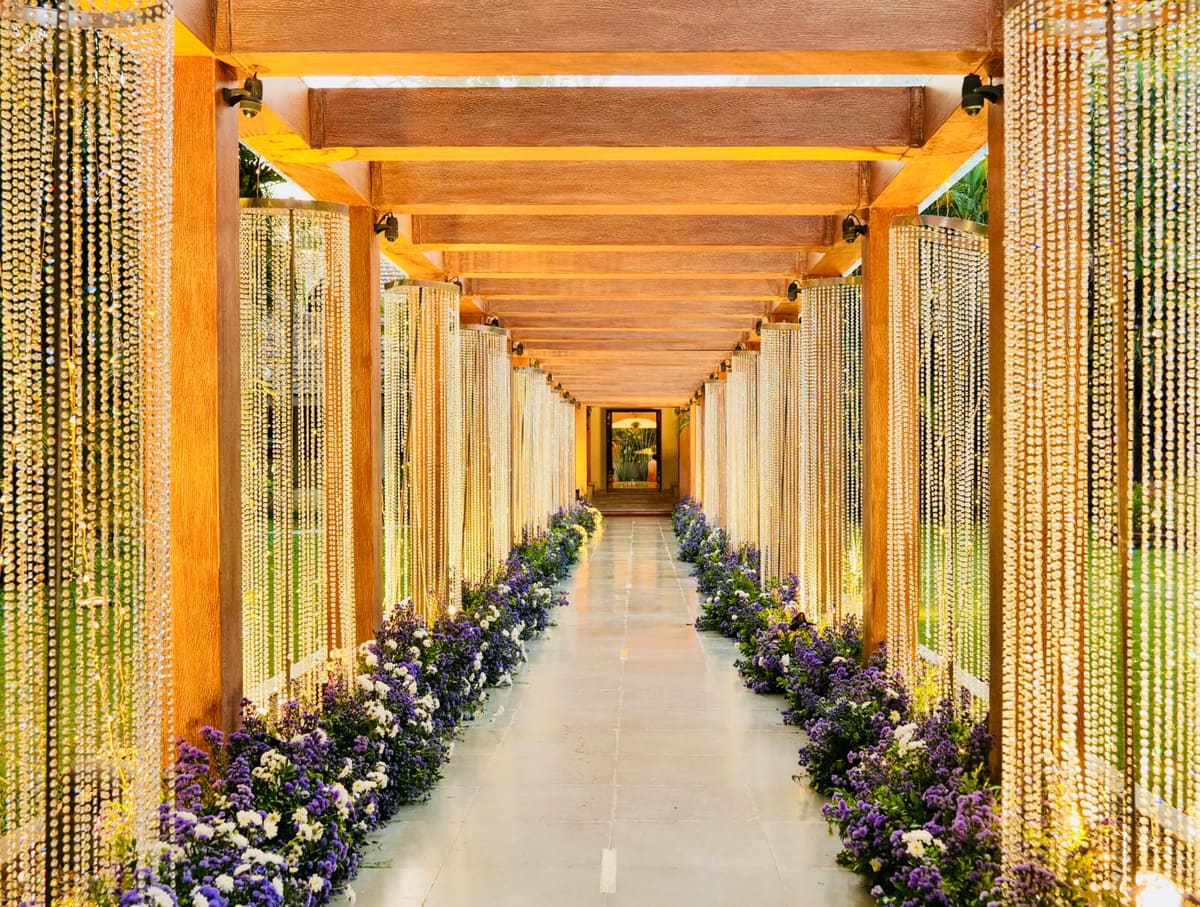 The Glass House walkway dressed for a wedding with golden bead strings and fresh flowers
