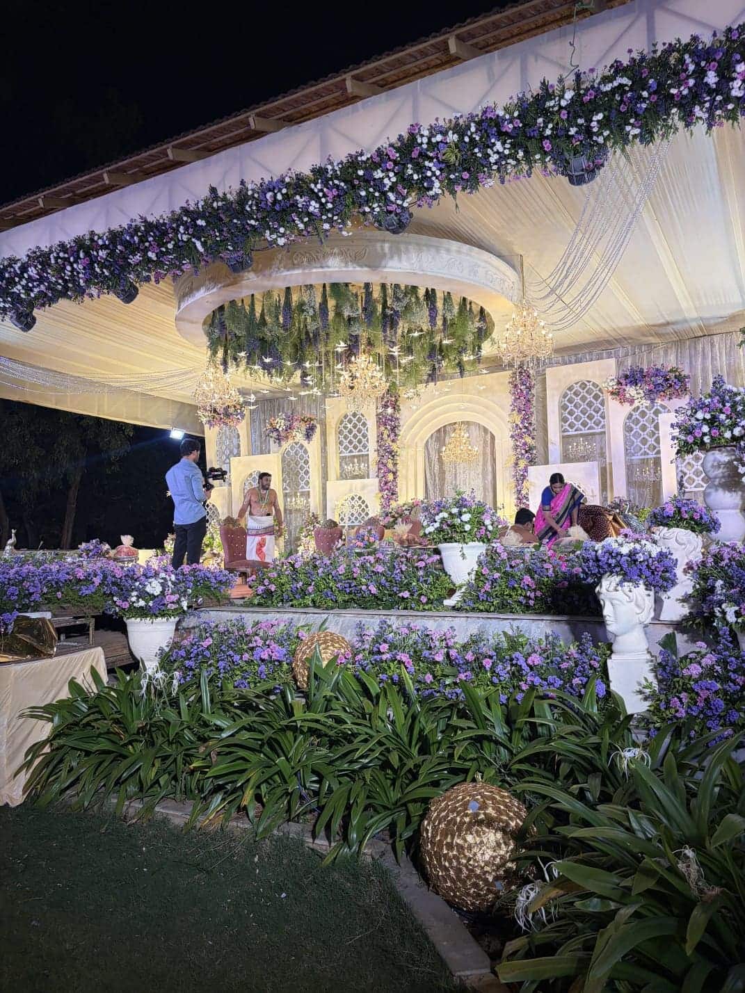 Evening wedding dinner laid under a decorated canopy